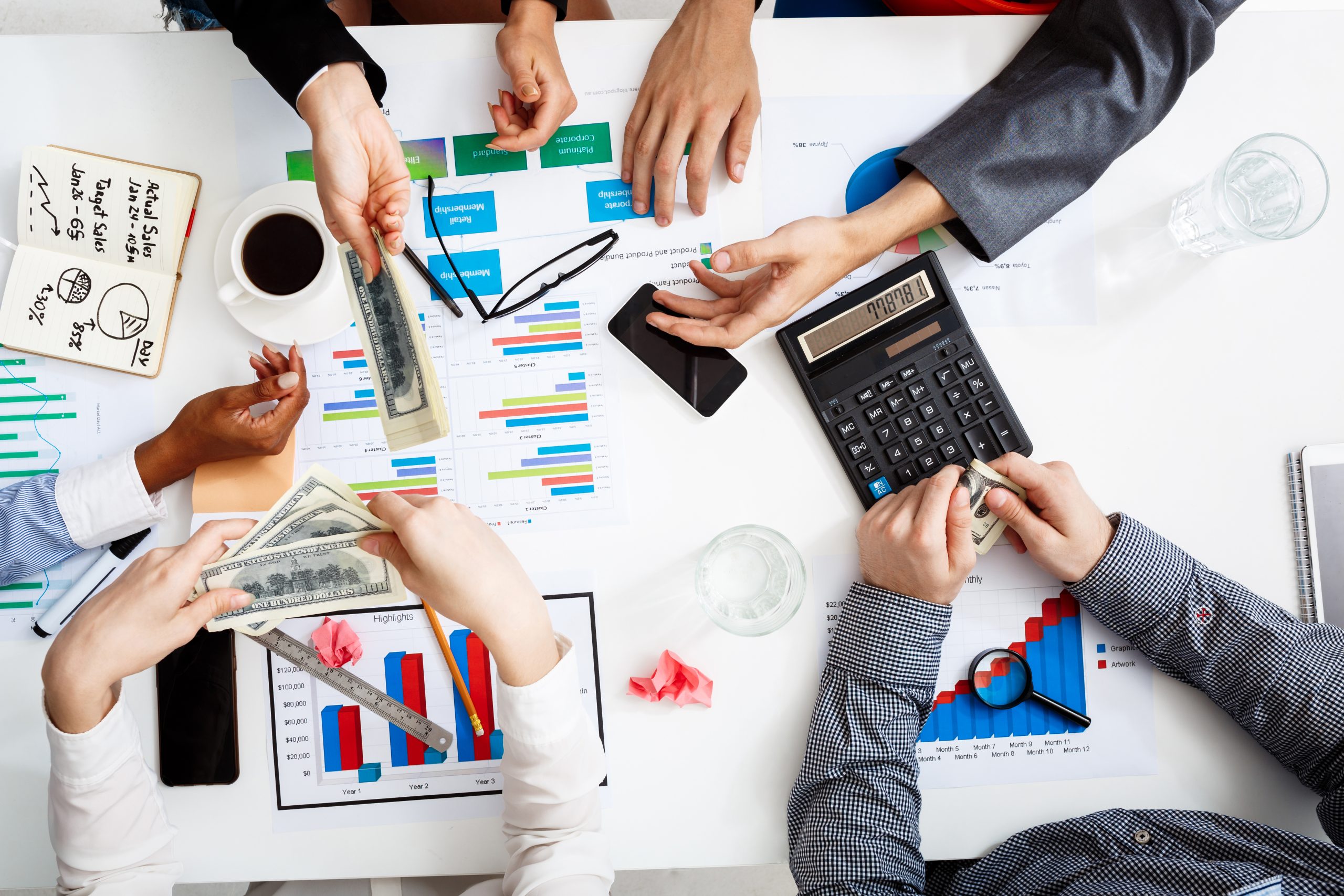 picture of businessmen's hands on white table with documents and drafts